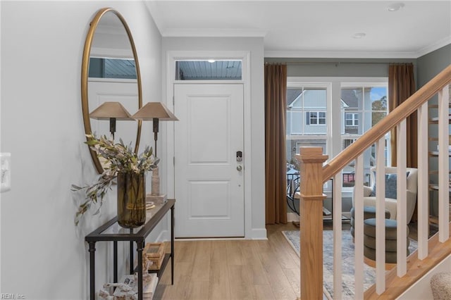 entryway featuring stairway, ornamental molding, and light wood-style flooring