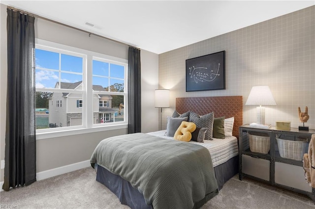 bedroom with light carpet, visible vents, and baseboards