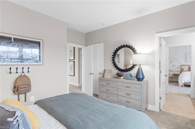 bedroom with light colored carpet and baseboards