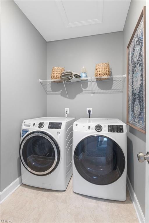 washroom with laundry area, washing machine and dryer, and baseboards