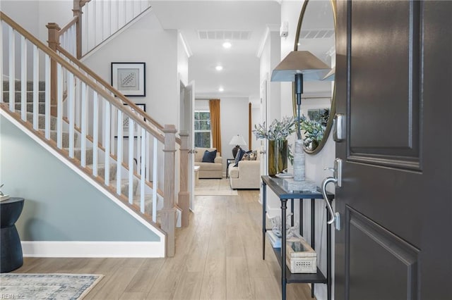 foyer entrance featuring recessed lighting, visible vents, baseboards, ornamental molding, and light wood finished floors