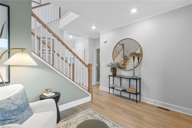 interior space featuring light wood-style floors, visible vents, baseboards, and stairs