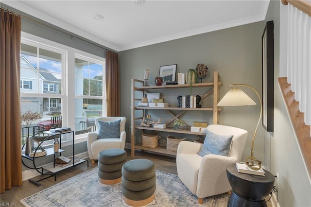 living area featuring ornamental molding, baseboards, and wood finished floors