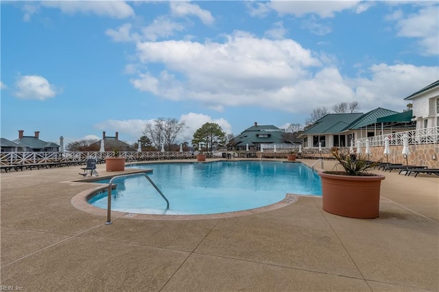 community pool with fence and a patio