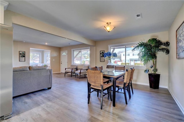 dining room with wood finished floors, visible vents, and baseboards