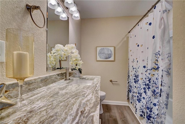 bathroom with toilet, curtained shower, wood finished floors, and vanity