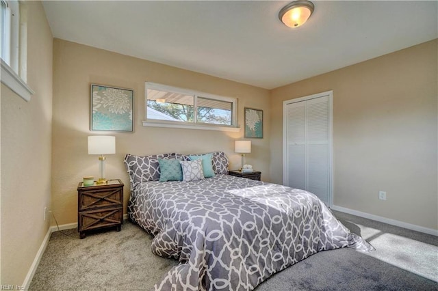 bedroom with baseboards, a closet, and light colored carpet