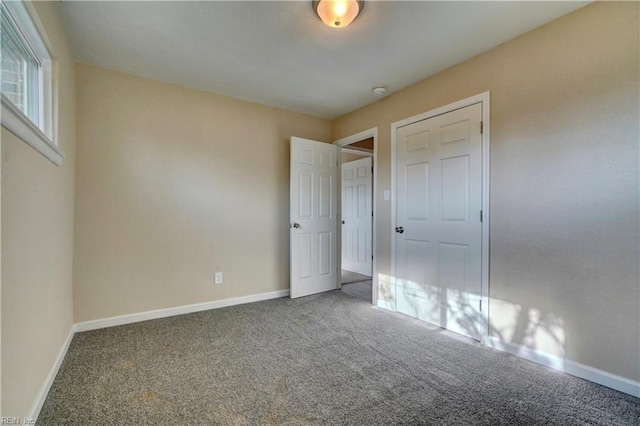 unfurnished bedroom featuring carpet floors and baseboards