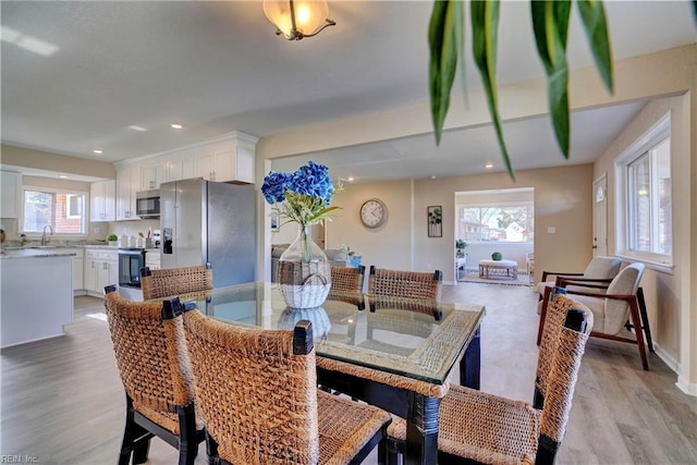 dining area with baseboards, light wood-style flooring, and recessed lighting