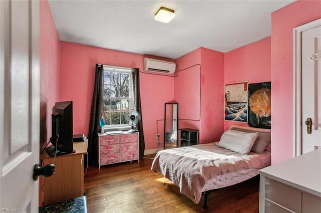 bedroom featuring dark wood-style flooring and a wall mounted AC