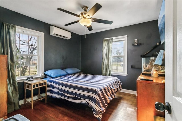 bedroom with ceiling fan, a wall mounted AC, dark wood finished floors, and baseboards