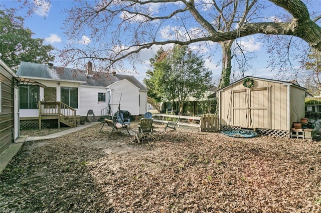 view of yard featuring fence, a storage unit, and an outdoor structure