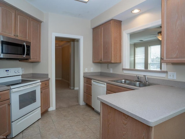 kitchen featuring white appliances, ceiling fan, light countertops, a sink, and recessed lighting