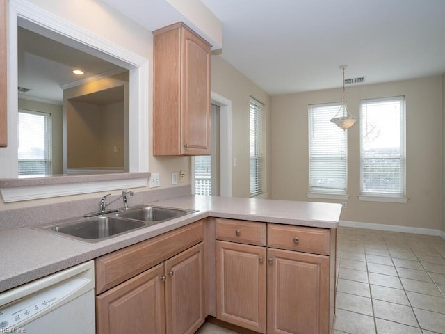 kitchen featuring visible vents, light countertops, white dishwasher, a sink, and a peninsula