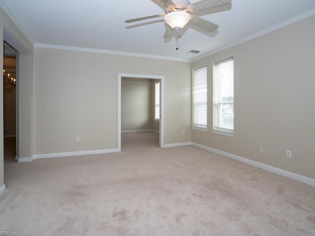 empty room with crown molding, light colored carpet, visible vents, ceiling fan, and baseboards