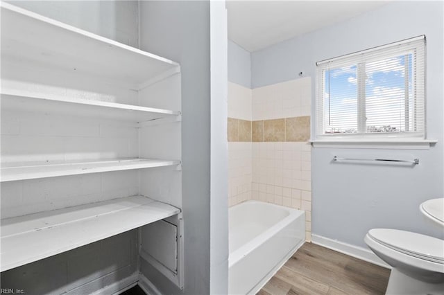 bathroom featuring toilet, baseboards, and wood finished floors