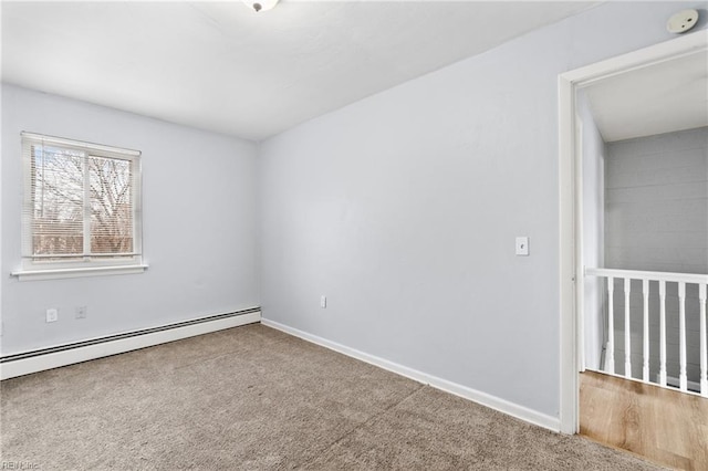 spare room with baseboards, baseboard heating, and carpet flooring