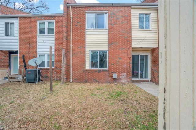 rear view of property featuring a yard and brick siding