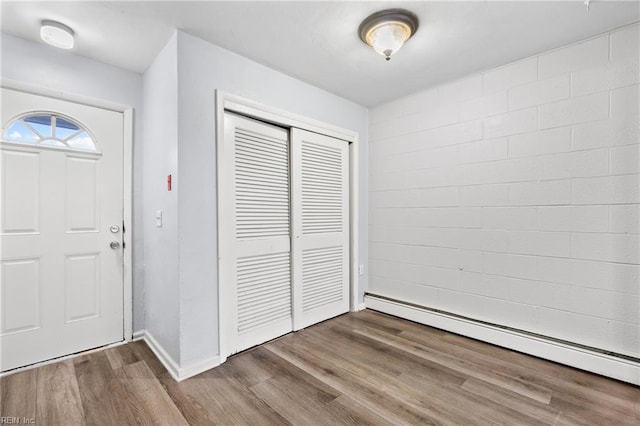 entrance foyer featuring baseboards, baseboard heating, and wood finished floors