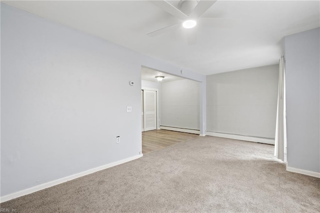 unfurnished room featuring a baseboard heating unit, light carpet, a ceiling fan, and baseboards