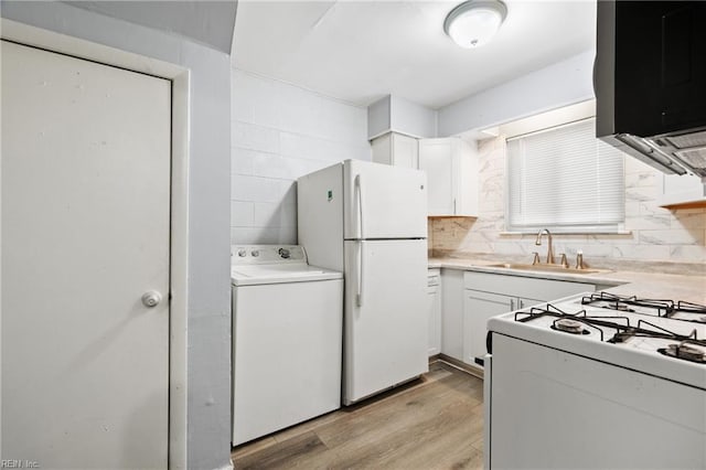 kitchen featuring light countertops, washer / clothes dryer, white cabinets, and a sink