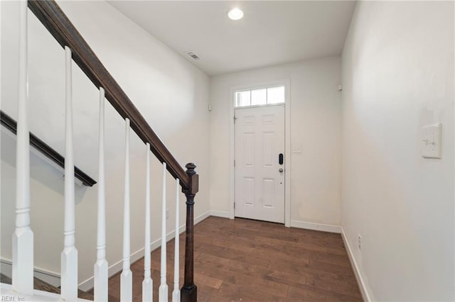 foyer entrance featuring dark wood-type flooring, recessed lighting, baseboards, and stairs