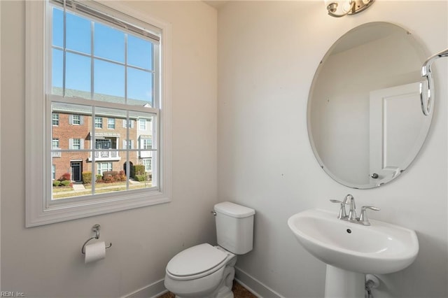 bathroom with baseboards, a sink, and toilet