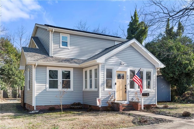 view of front of property with entry steps and a shingled roof