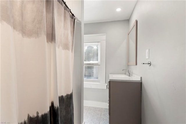 full bath with vanity and baseboards