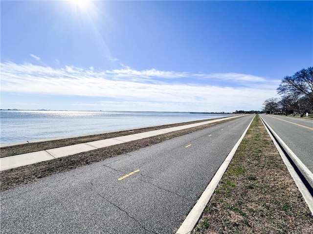 view of street featuring a water view and sidewalks