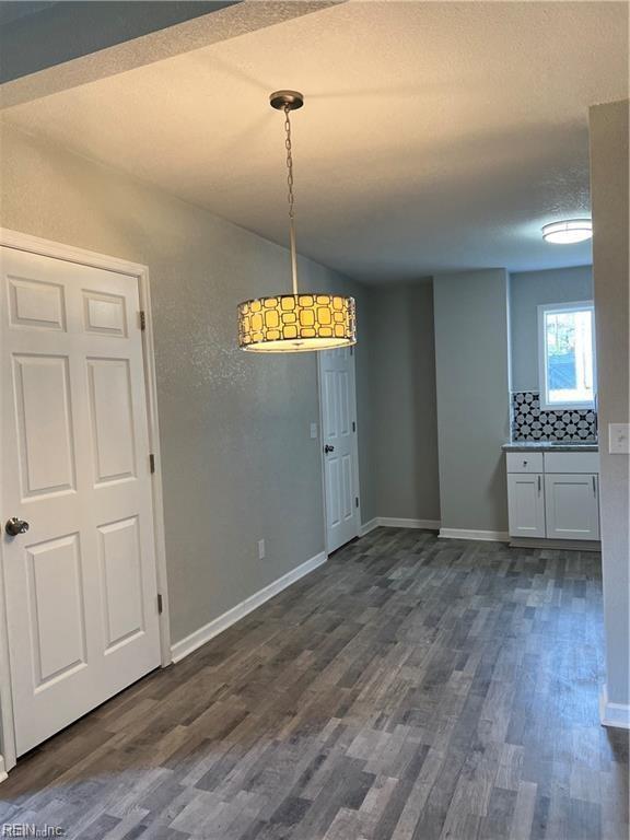 211 Central Ave, Suffolk, VA 23434 - unfurnished dining area featuring lofted ceiling, a textured ceiling, baseboards, and dark wood-style flooring