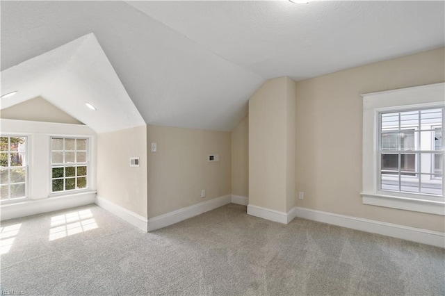 bonus room featuring light carpet, vaulted ceiling, and baseboards