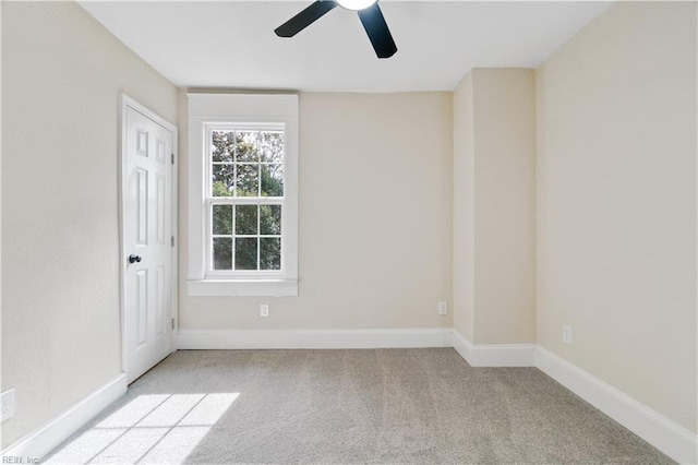 spare room with ceiling fan, baseboards, and light colored carpet