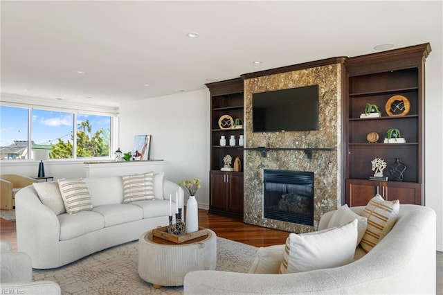 living room featuring wood finished floors, a high end fireplace, and recessed lighting