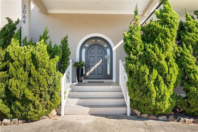 entrance to property featuring stucco siding