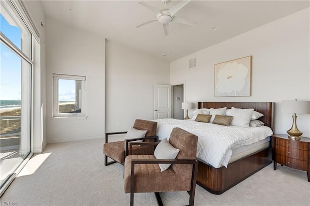 bedroom featuring high vaulted ceiling, multiple windows, visible vents, and light colored carpet