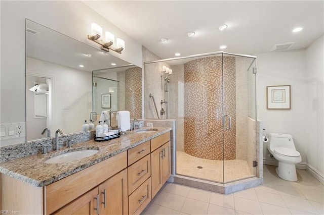 bathroom with double vanity, a sink, toilet, and a shower stall