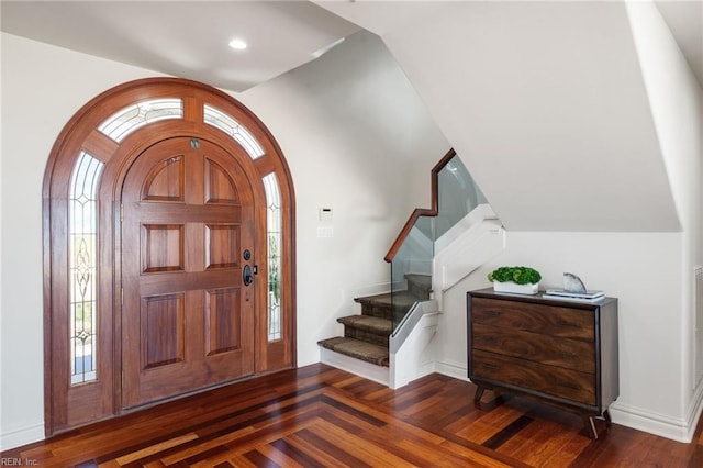 foyer featuring arched walkways, dark wood-style floors, stairway, vaulted ceiling, and recessed lighting