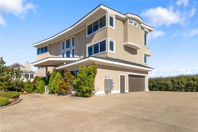 view of property with a garage and concrete driveway