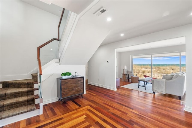 interior space with baseboards, stairs, visible vents, and wood finished floors