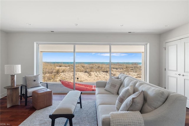 living area with visible vents, dark wood-type flooring, and a wealth of natural light