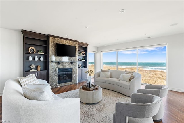 living area with recessed lighting, a large fireplace, baseboards, and wood finished floors