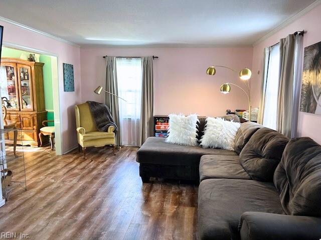 living area with ornamental molding and wood finished floors