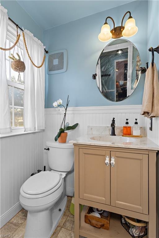 bathroom featuring wainscoting, vanity, and toilet