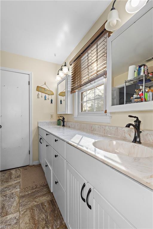 full bathroom with double vanity and a sink