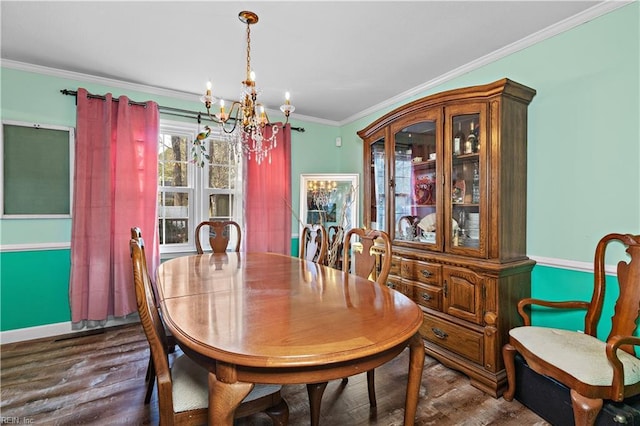 dining area featuring ornamental molding, dark wood finished floors, and a chandelier