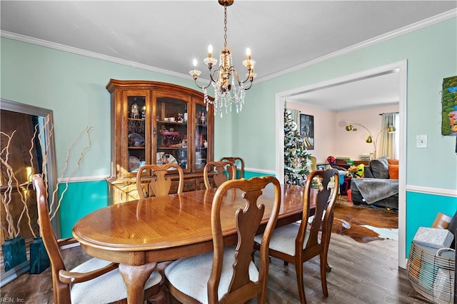 dining area featuring dark wood-style flooring, an inviting chandelier, and crown molding