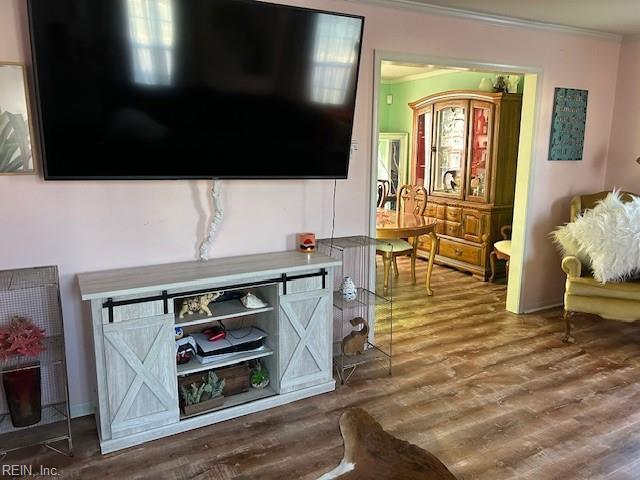 living room featuring crown molding and wood finished floors