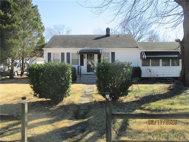 view of front of house with roof with shingles and a chimney