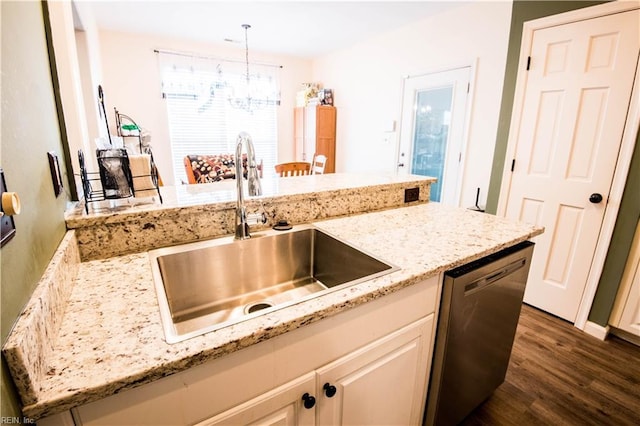 kitchen featuring dark wood-style flooring, decorative light fixtures, a sink, light stone countertops, and dishwasher